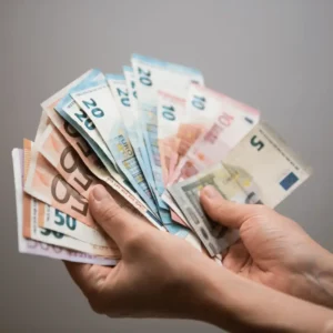 Strona Główna 33 Plik pieniędzy które są trzymane w ręce, obrazek sugeruje zwrot podatku po rozliczenia podatku w niemczech